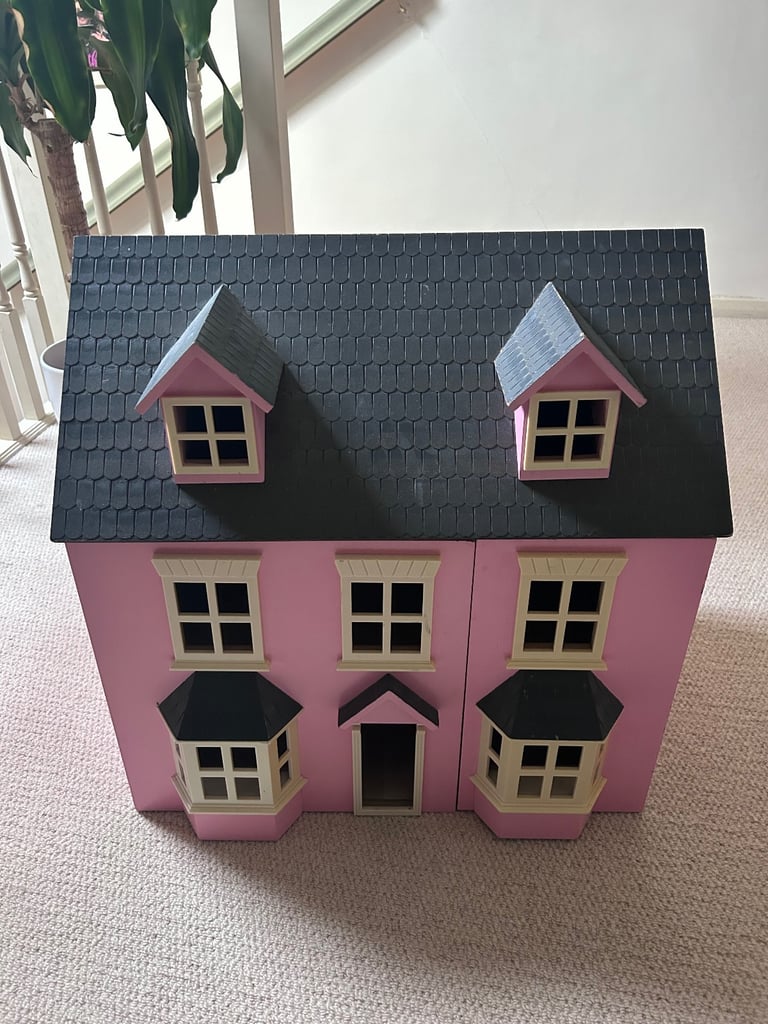 Pink dolls house with furniture and figures