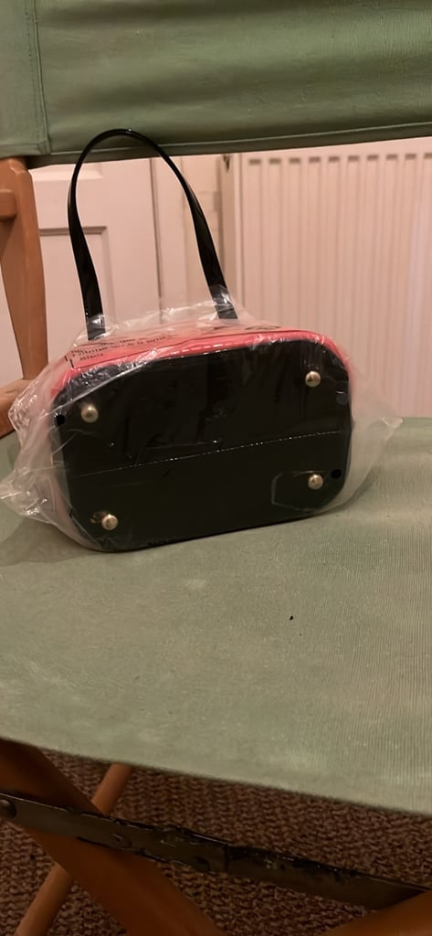 the handbag is a red, box-shaped handbag by the brand Gessy