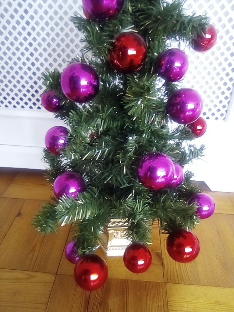 Small artificial Christmas tree, with bauble and other decorations.