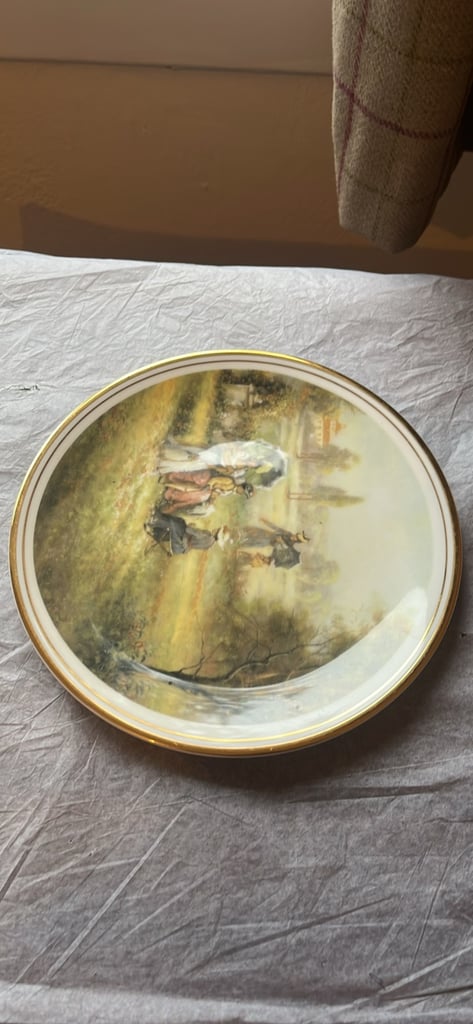 This is a collector's plate titled "Sunday in the Park" by C. Pila