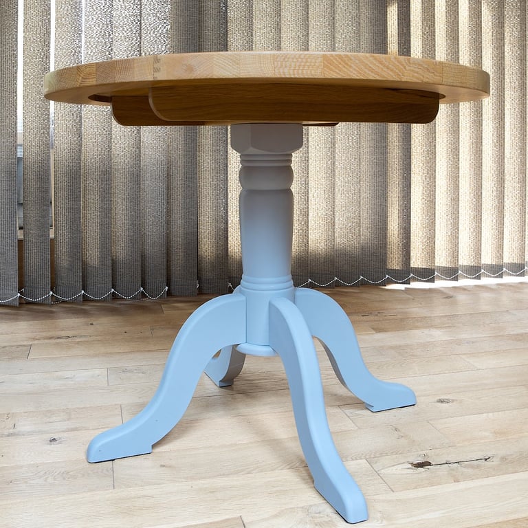 Solid oak circular dining table on a grey pedestal base