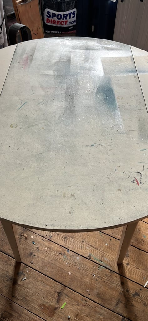 image for Wooden solid round fold up sides table with some spray paint on it 