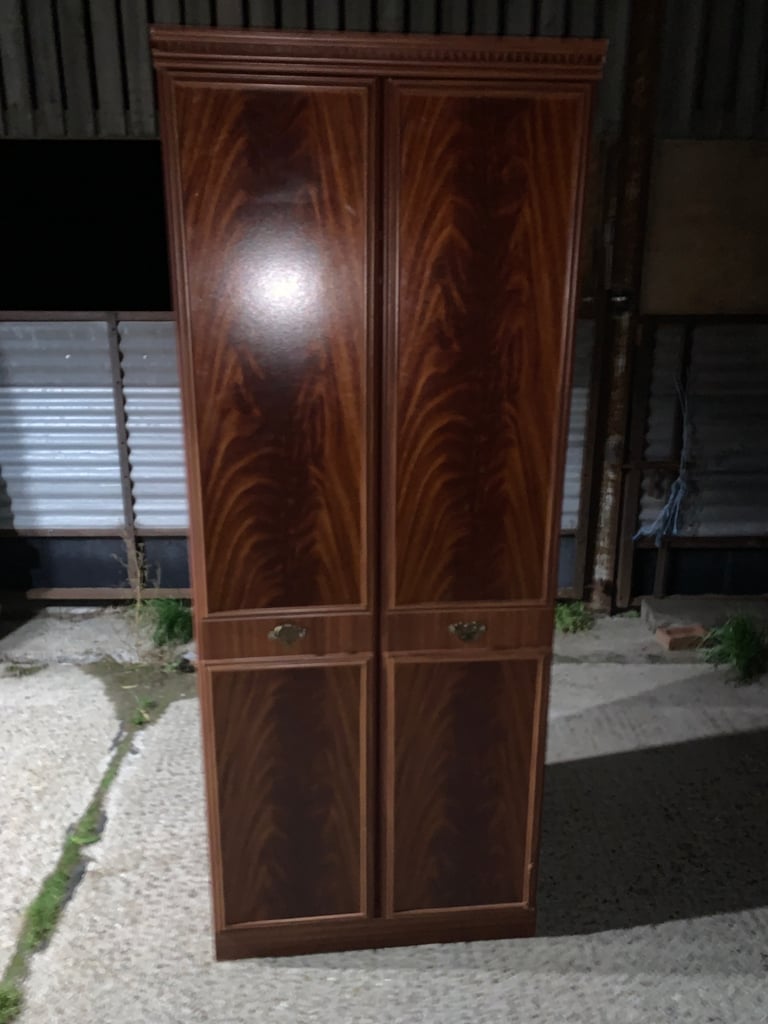 Elegant wooden wardrobe with decorative handles.