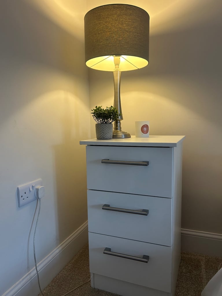 White bedside table with three drawers and silver handles