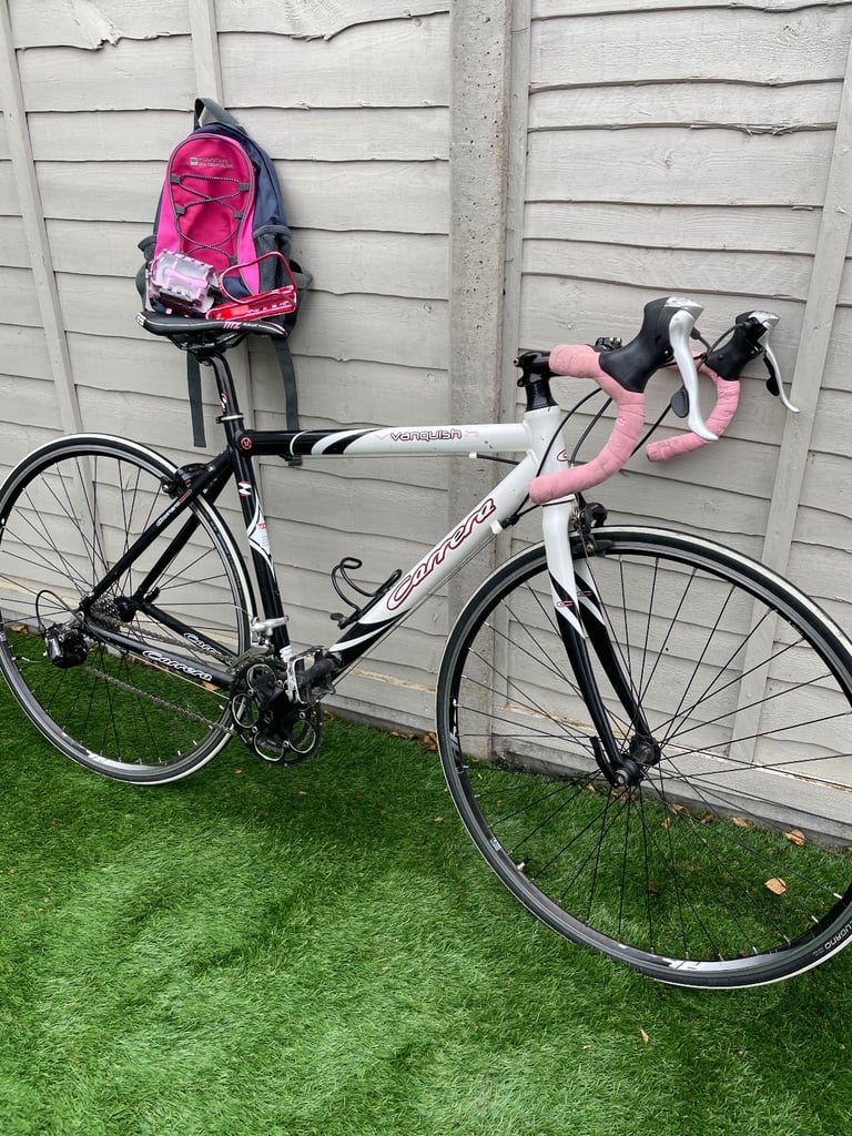 White Carrera Vanquish adult bike with pink trim and extra accessories.