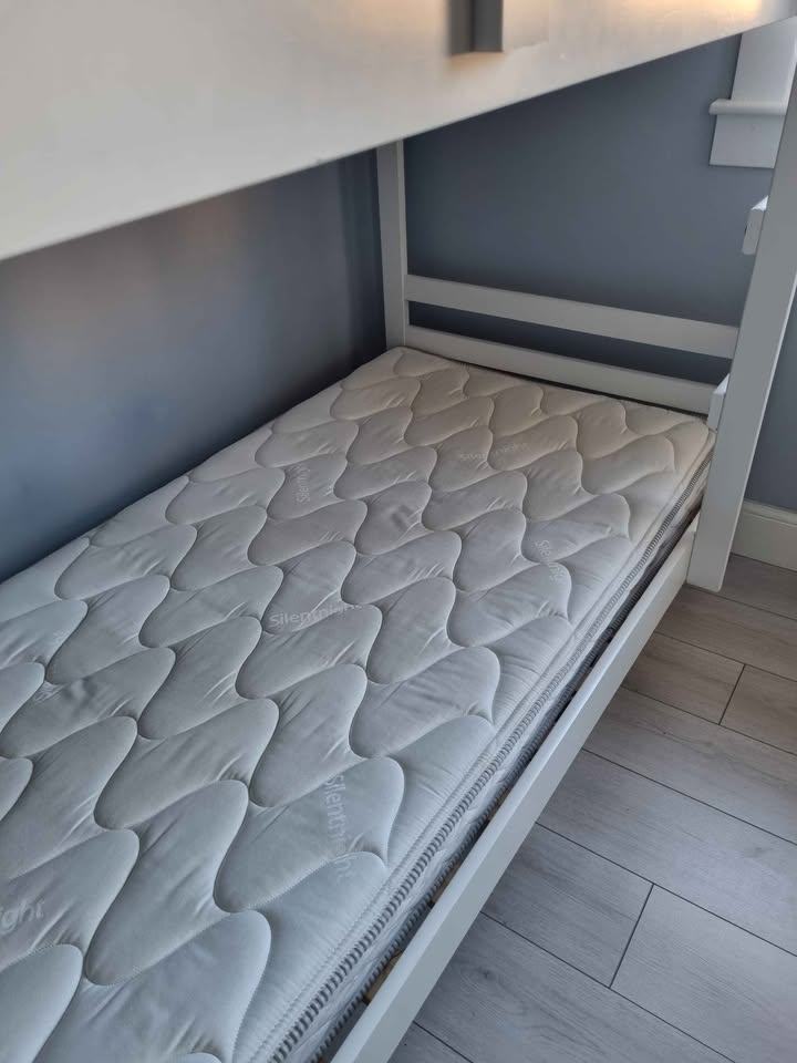 White wooden framed bunk beds with mattresses