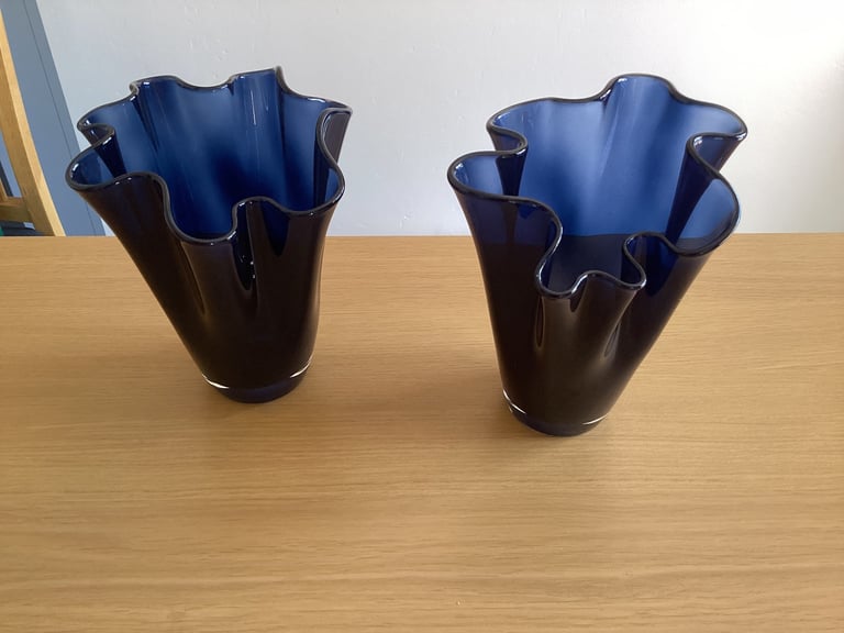 A pair of blue glass flower vases. 