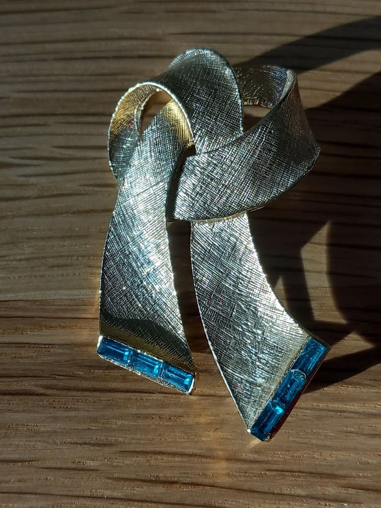 Gold coloured knot brooch with 3 baguette style turquoise cut glass stones, great gift idea