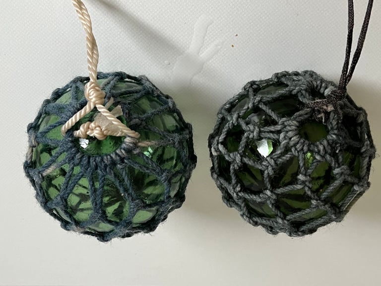 2 vintage green glass fishing floats in original string netting