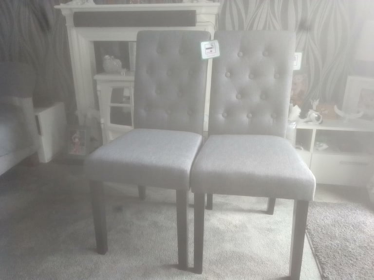 Two grey fabric ding room chairs 