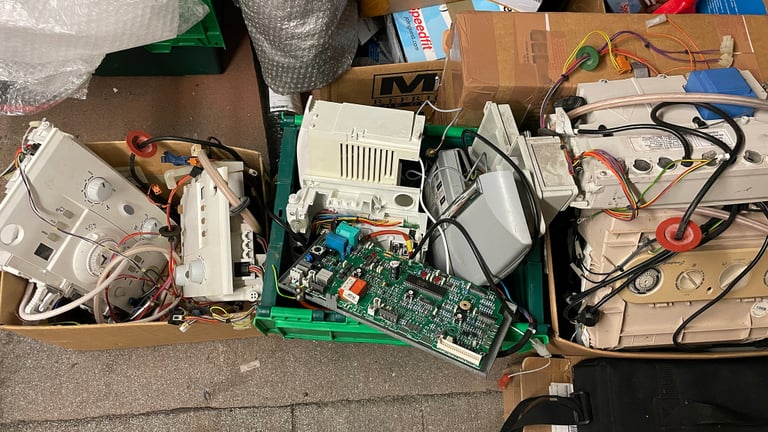 Boxes full of used combi boiler circuit boards etc