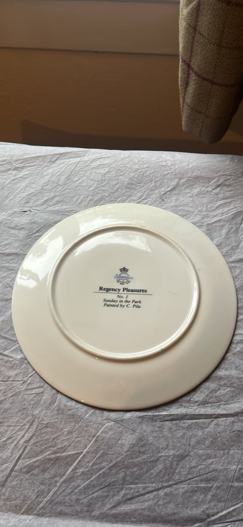 This is a collector's plate titled "Sunday in the Park" by C. Pila
