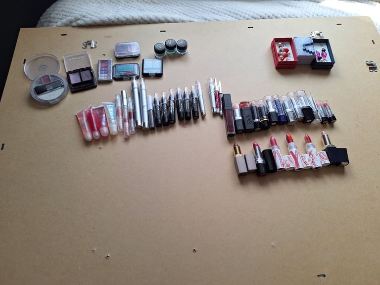 A bundle of ladies makeup lip stick new few used, earing new and eyeshadow 