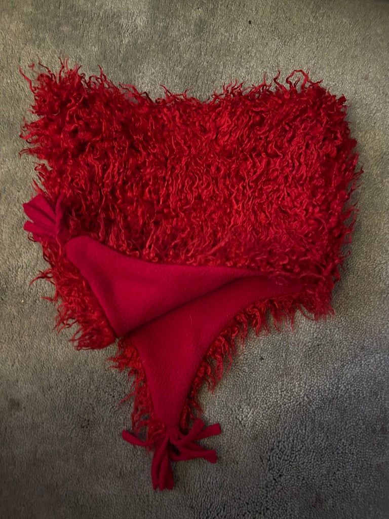 Red fuzzy fleece hat with tassels. .  