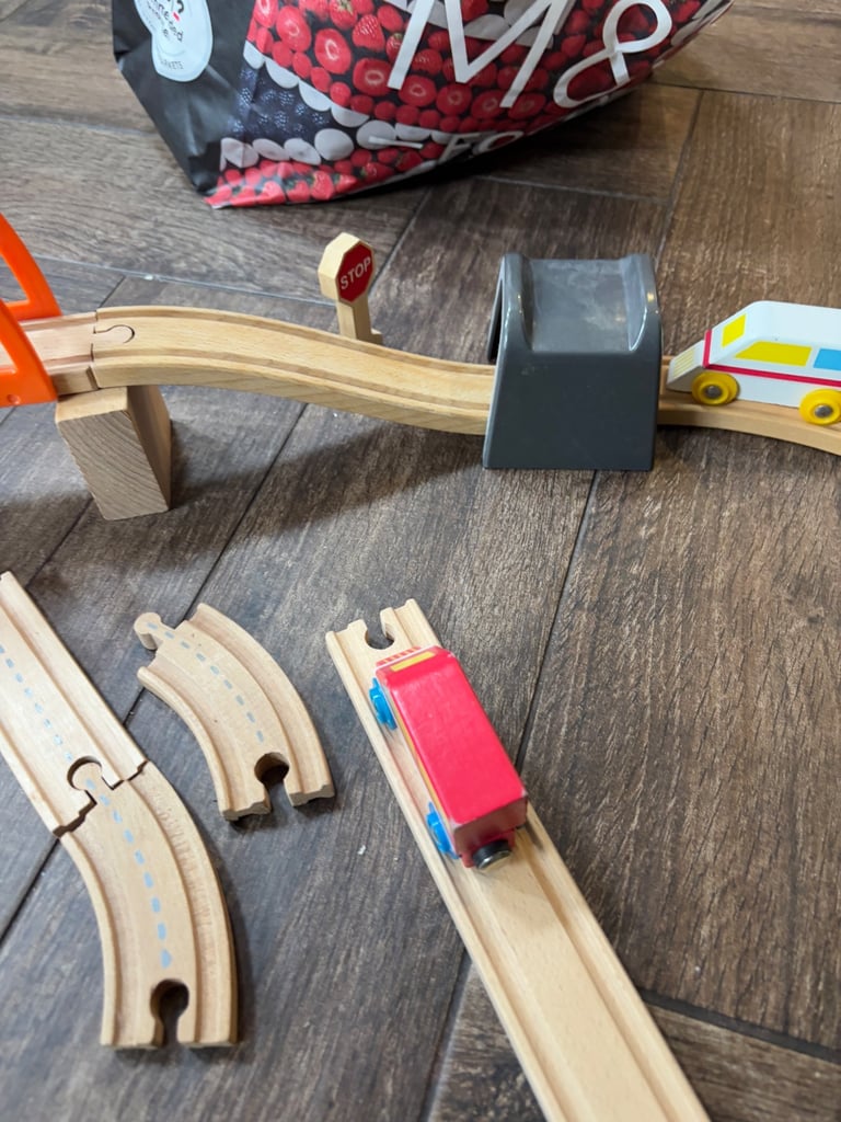 A bag full of wooden train track elements with many extras