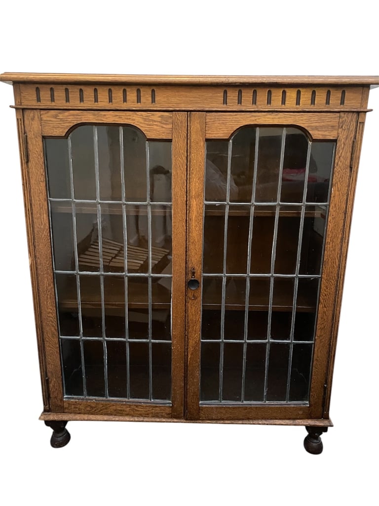 Antique leaded glass cabinet with carving detail and adjustable shelves.