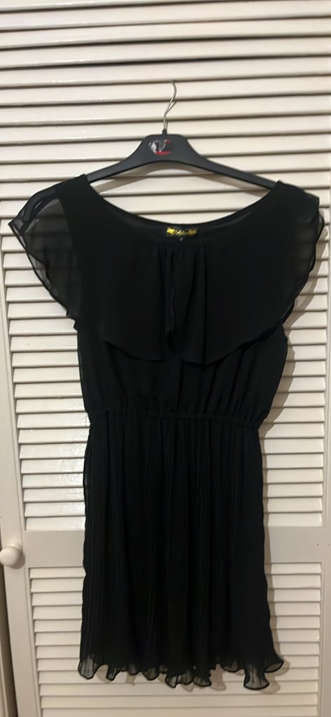 image for a black sleeveless dress with a ruffle top and a pleated skirt