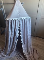 Grey bed canopy curtain with white Pom poms