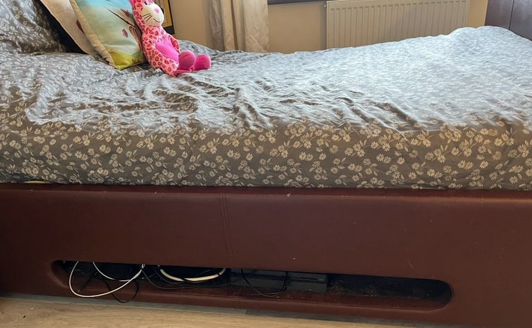 Brown leather double bed under ovening tv lift. 