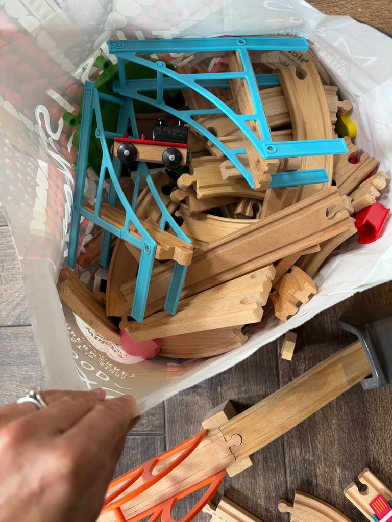 A bag full of wooden train track elements with many extras