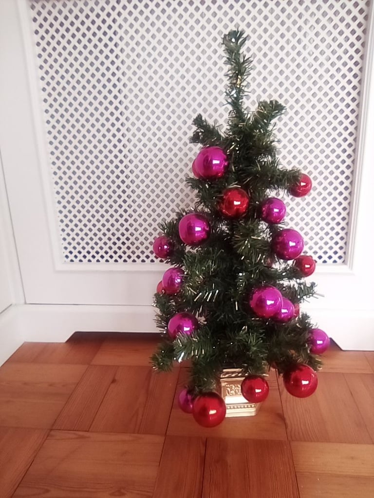 Small artificial Christmas tree, with bauble and other decorations.