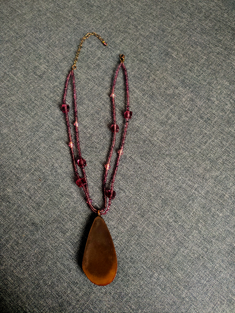 Beautiful glass pendant with glass beads set in metal (possibly copper?).