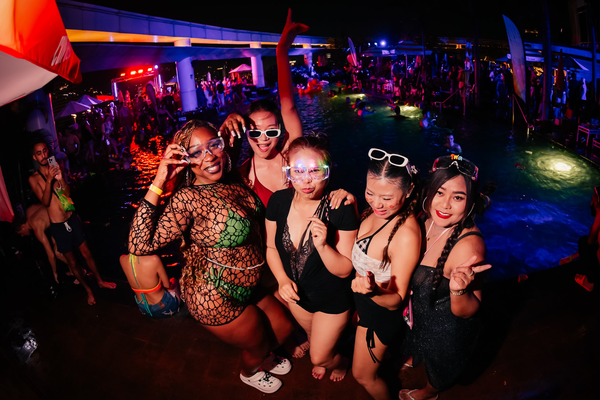 Friends enjoying the night-time poolside atmosphere at a Bangkok Rooftops pool party, Centara Grand at CentralWorld