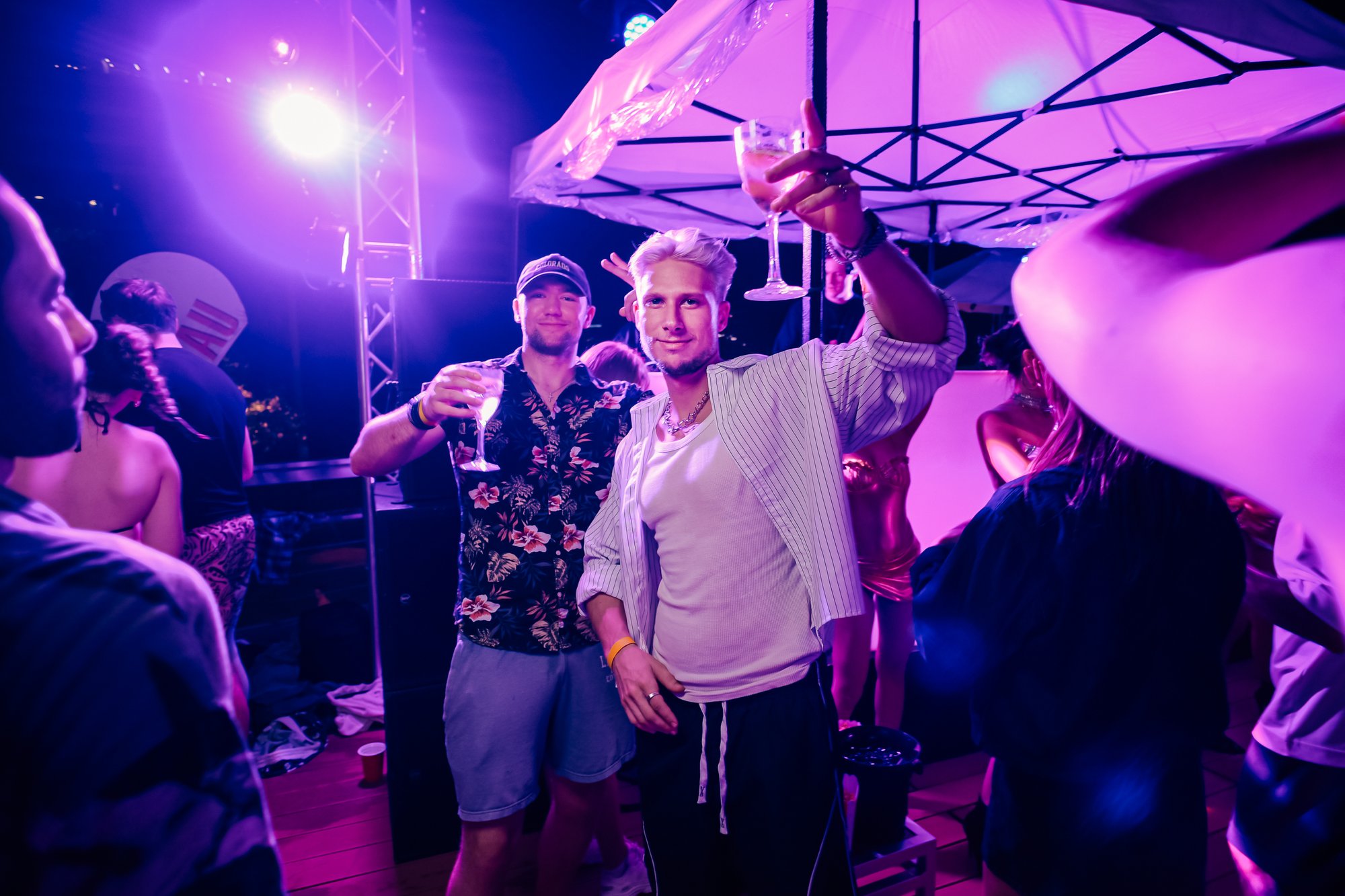 Guests raising glasses under the party tents at a Centara Grand rooftop pool party