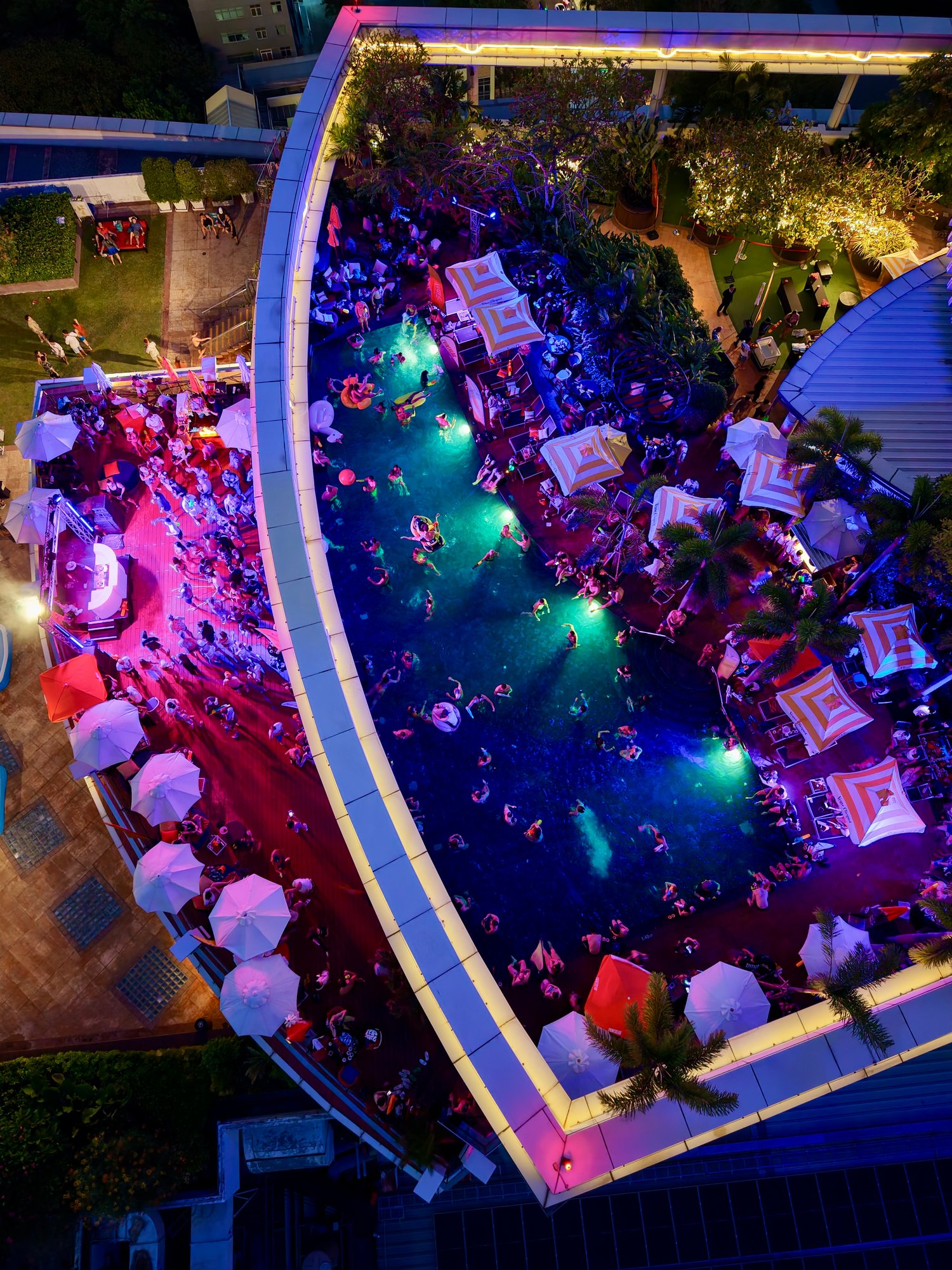 Aerial view of a Bangkok rooftop pool party at dusk — Centara Grand at CentralWorld
