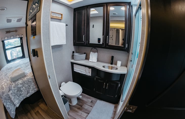 plenty of room in the bathroom, along with storage above the sink.  Fan vent above to keep things cool while showering.