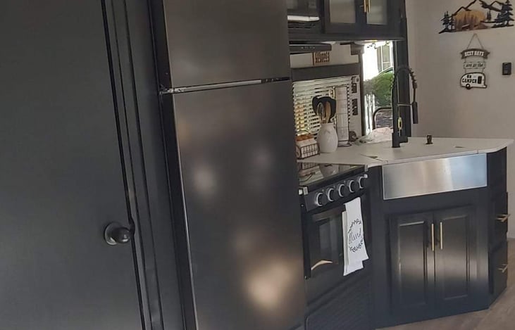 Large fridge and freezer as well as floor to ceiling pantry! Overhead cabinets for dishes, microwave, stove, oven, large sink with cover. Pots, pans, plates, bowls, cups, cooking utensils included.