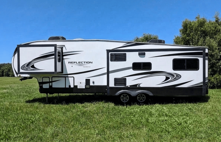 Spacious 2022 Grand Design Reflection 340RDS 5th wheel! Features a signature rear den with dual sofas, theater seating, fireplace, gourmet kitchen, king/queen bed, and 3 slides for ultimate luxury.