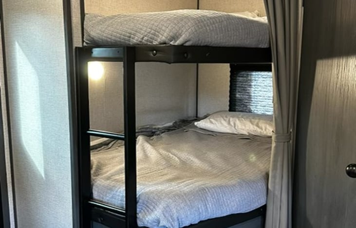 Bunk beds with sheets, blankets, and pillows provided and usb ports up top.