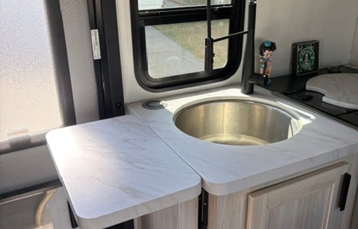 Kitchen counter flips up for more workspace and sink cover allows for more counter top.