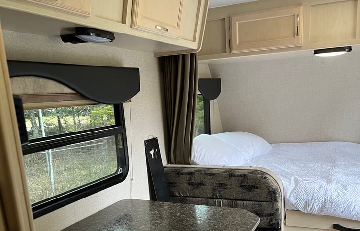 Lots of overhead cabinet space and a curtain divider for the bed. The dinette converts to small bed.