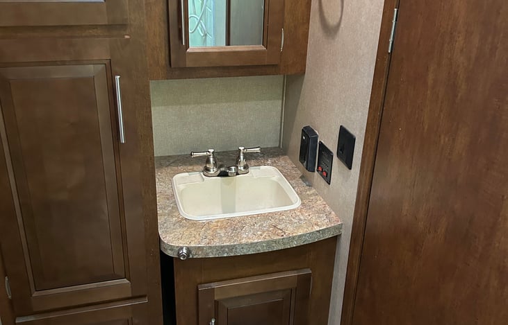 Bathroom with toilet and full-size shower storage are next to sink