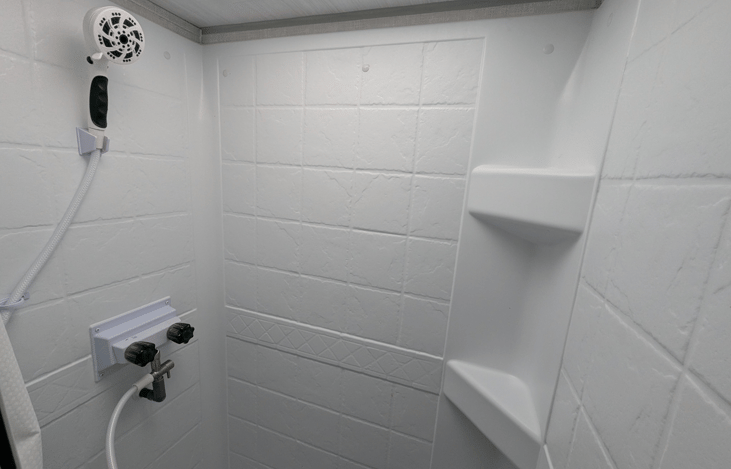 Walk-through bathroom with ample storage space and tall shower.