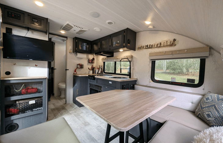 Cozy, modern and bright living area with well-equipped kitchen, TV, large dinette that converts to a bed, pop-out window and whimsical touches throughout.