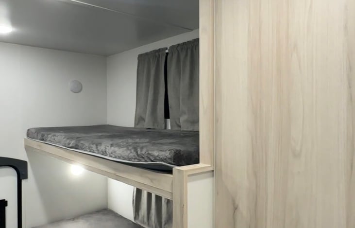 Double bunk area: We use the top bunk for storing our things like backpacks, battery packs, electronics, etc. The bottom bunk becomes part of our bed at night when the couch is unfolded up to it.