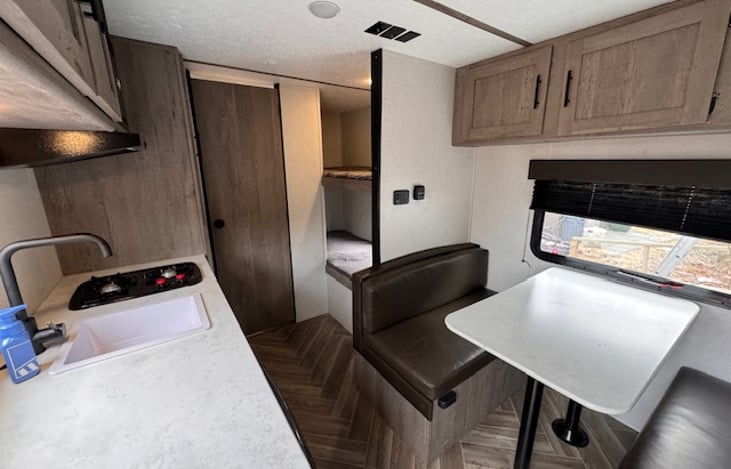 Wide angle view from the door. You can see the kitchen, bathroom, bunks, and dinette.