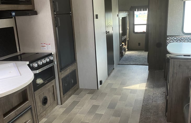 Stovetop, oven, large refrigerator and separate freezer on top.