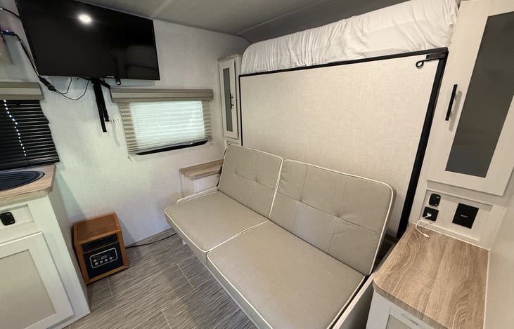 Living room couch, TV and electric heater.