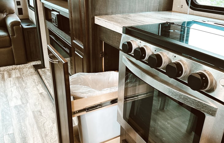 Upscale cabinetry with built in trash receptacle.