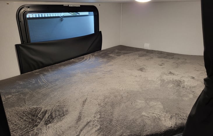 Lower bunk with snap on blackout window cover.  Electric receptacles located under this bunk.