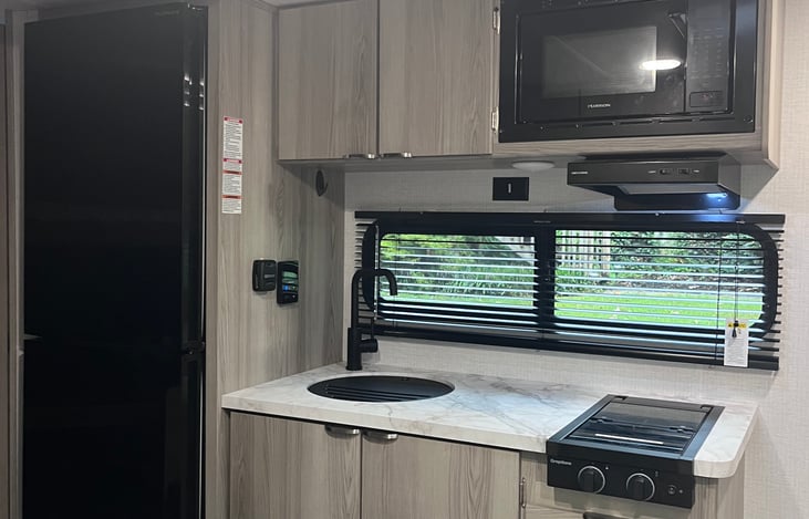 Kitchen includes nice size refrigerator and freezer, microwave, 2 burner gas stove and sink.