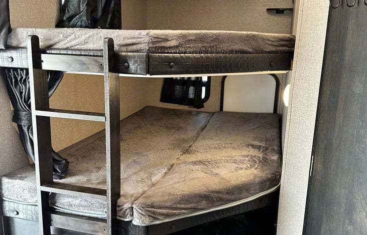 2 full size bunk beds for all the kiddos. Bottom bunk does fold half up for travel and access from back door .