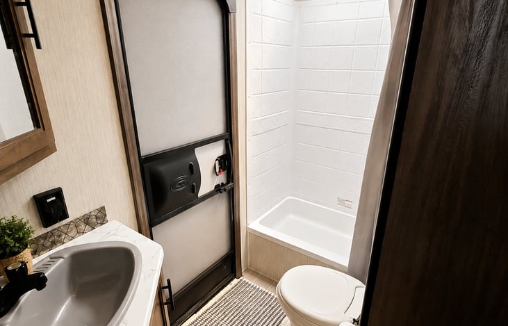 The 5 O’Clock Somewhere features a private bathroom with a toilet and shower, PLUS its own exterior entry/exit door—making bathroom access quick and convenient without walking through the entire RV!