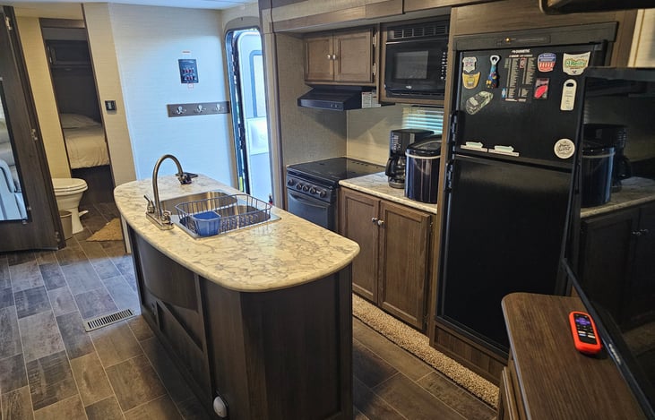 Extra large living area with two slide-outs and an island sink. TV with Roku device. Indoor and outdoor Bluetooth soundbar. Fold out couch and convertible sleeper dinette.
