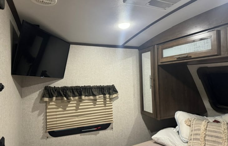 Master Bedroom King Size bed in the front with 32" Smart TV and storage.