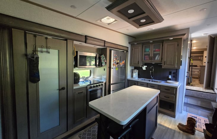 Large kitchen with coffee maker, residential fridge, air fryer, stove and microwave